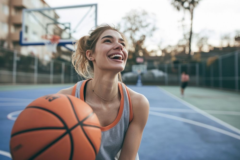 Mid adult woman playing basketball sports happy competition.
