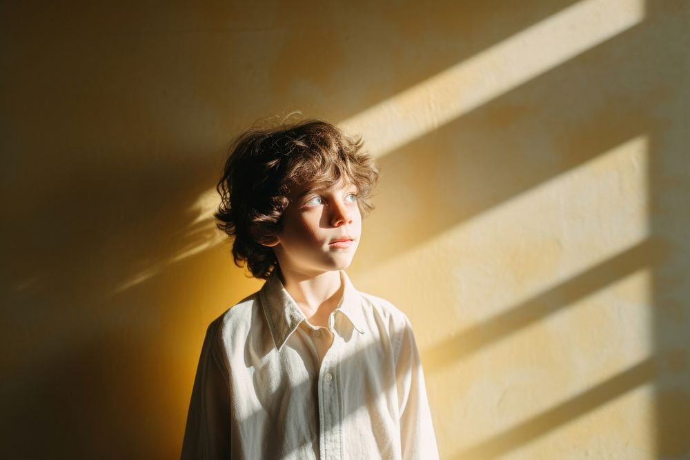 Autistic child holding in a minimalist portrait sunlight shadow.