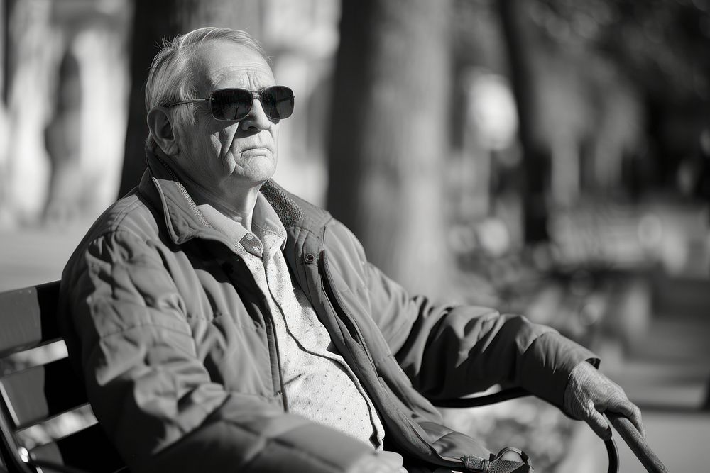A blind man glasses sitting bench.