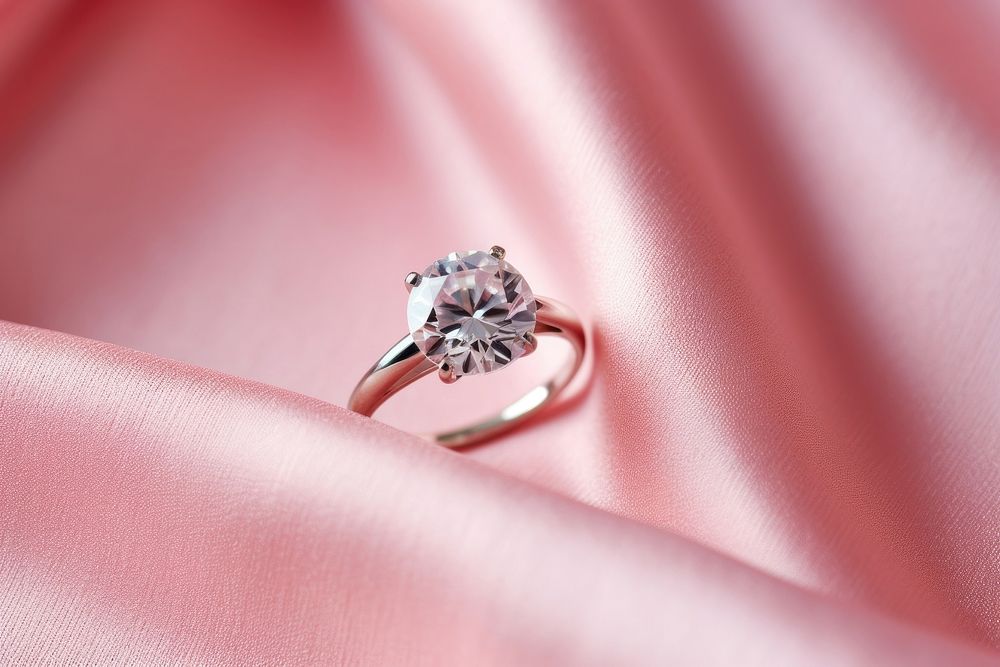 Pink diamonds ring on pink fabric gemstone jewelry silver.