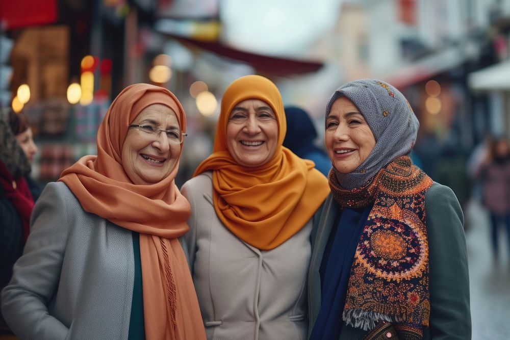 Three Muslim mature woman shopping together laughing scarf happy.