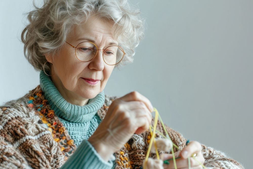 Mature woman watching tutorials for knitting grandmother accessories relaxation.