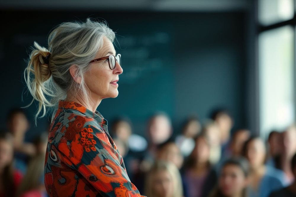 Mature woman teacher doing a presentation portrait audience glasses.