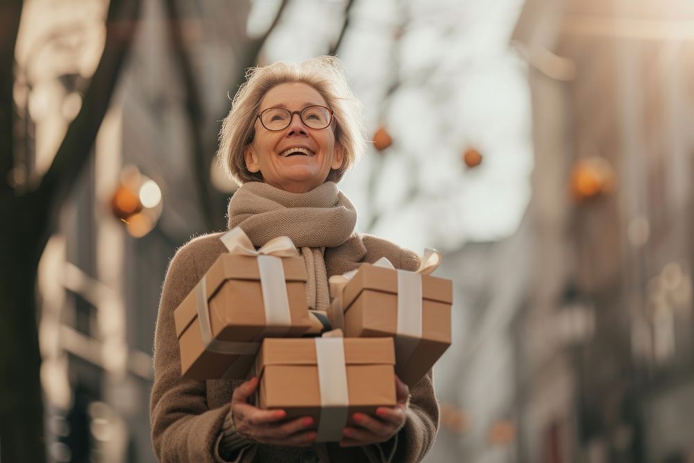 A joyful mature woman with a stack boxes holiday adult architecture.