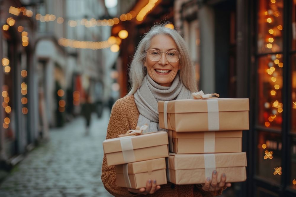 A joyful mature woman with a stack boxes holiday smile architecture.