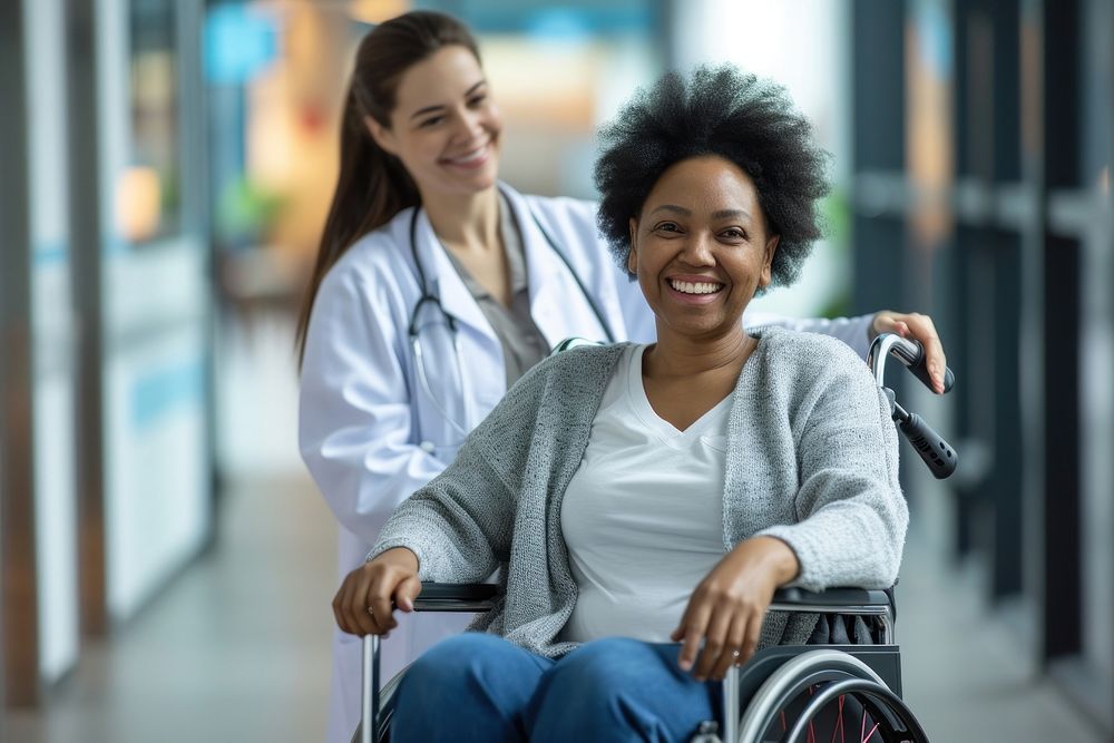 Joyful mature black woman sitting on wheelchair female adult nurse.