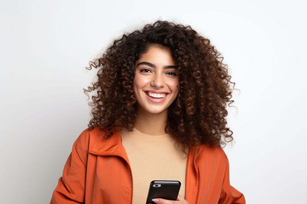 Young adult smiling happy pretty latin woman holding mobile phone device smile white background photographing.