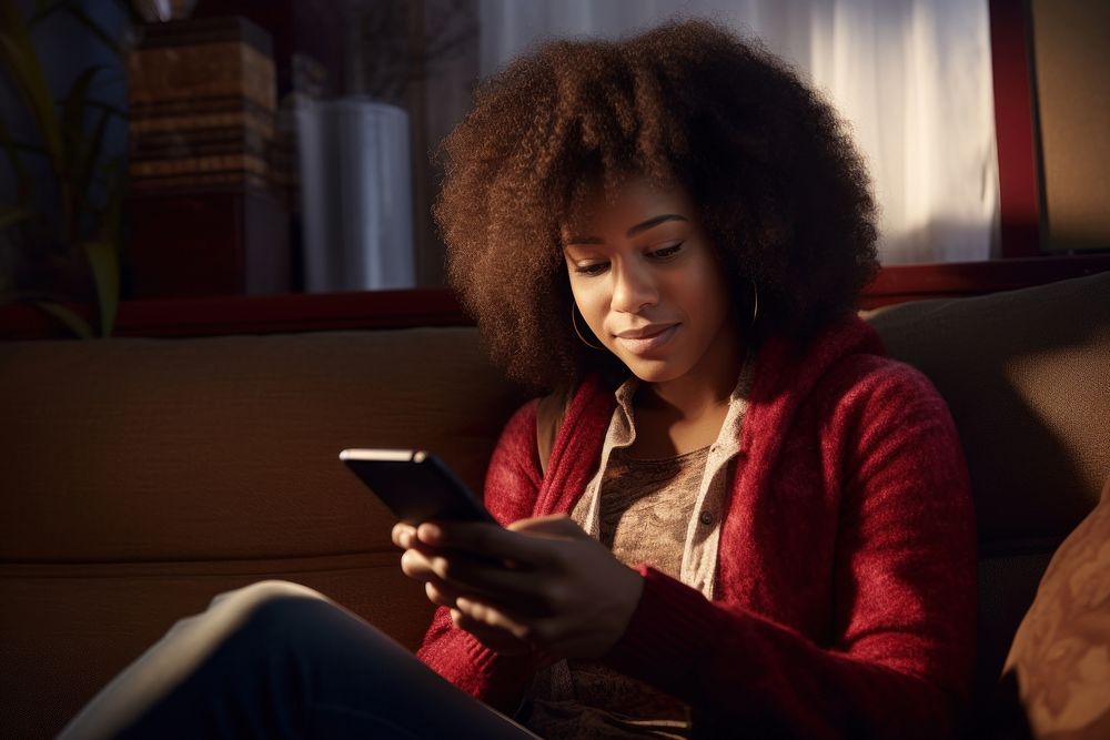 African-american woman looking at smartphone adult sofa head.