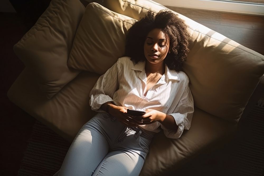 African-american woman with smartphone furniture adult sofa.