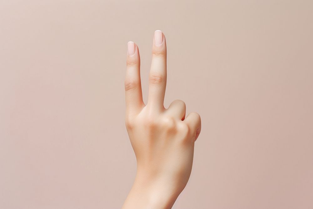 The finger of a woman displaying the okay sign hand fingernail gesturing.