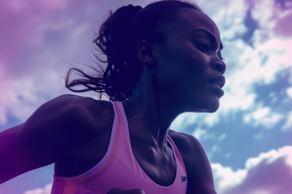 Black female athlete is running purple determination exercising.