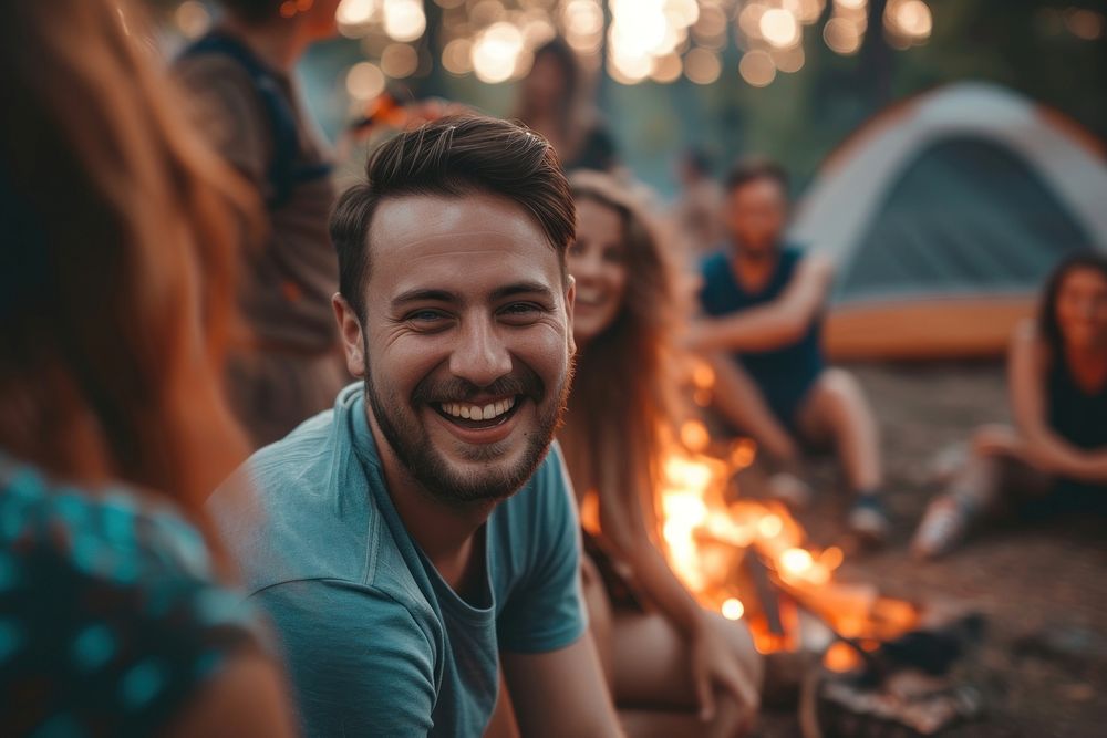 Happy people camping laughing outdoors.