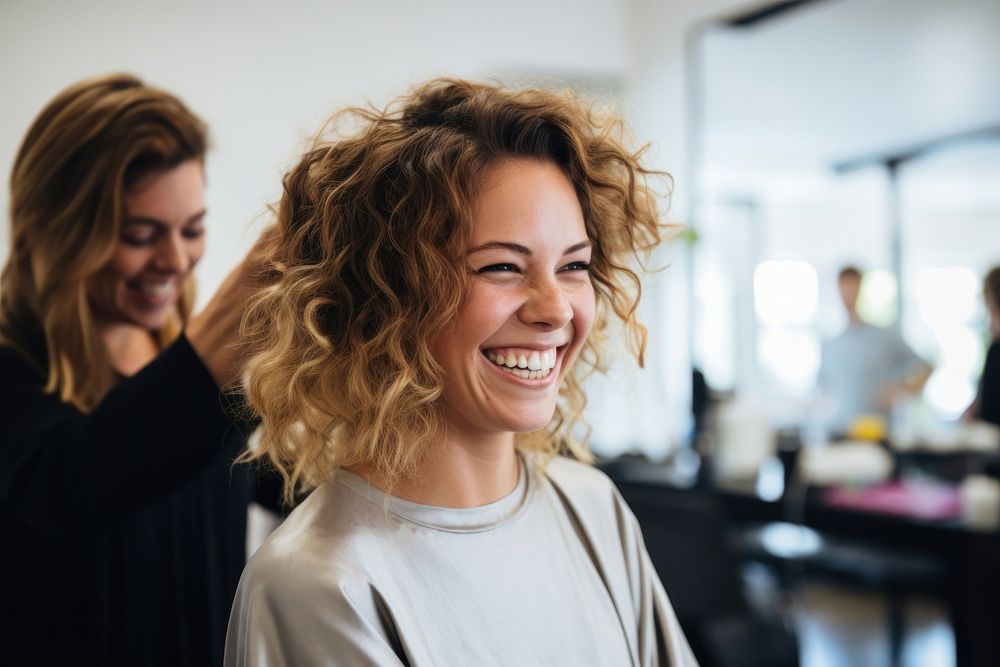 Hairdresser styling curly hair laughing adult smile.