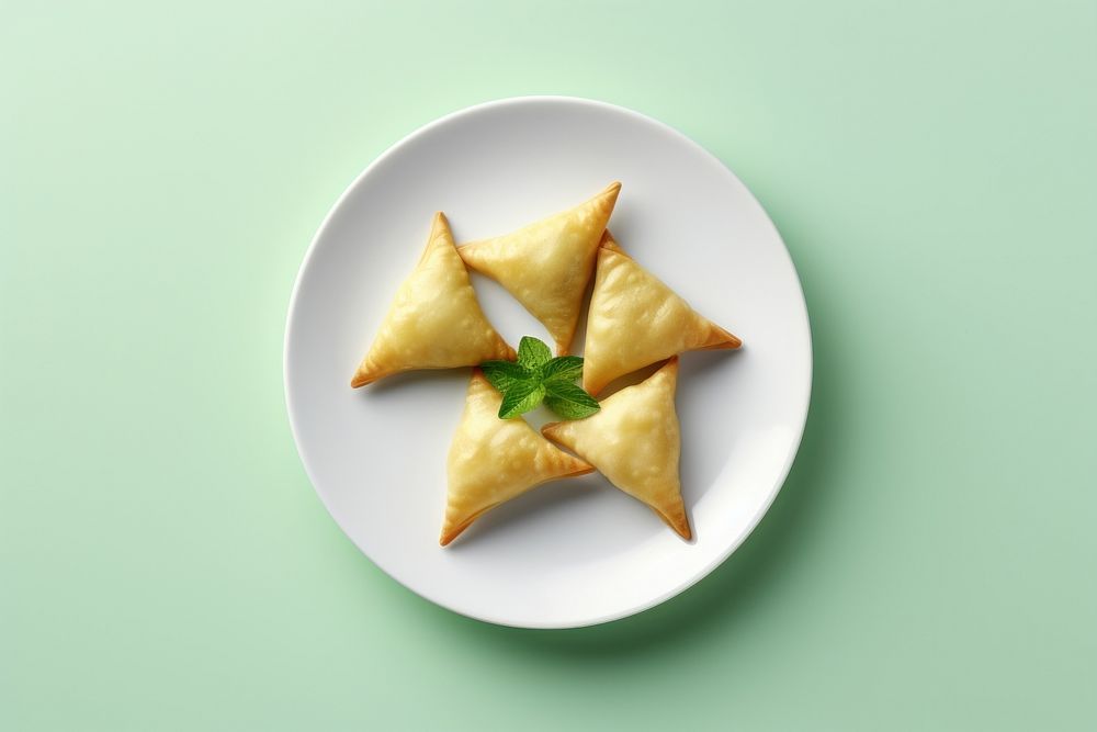 Samosas on a white plate dessert green food.