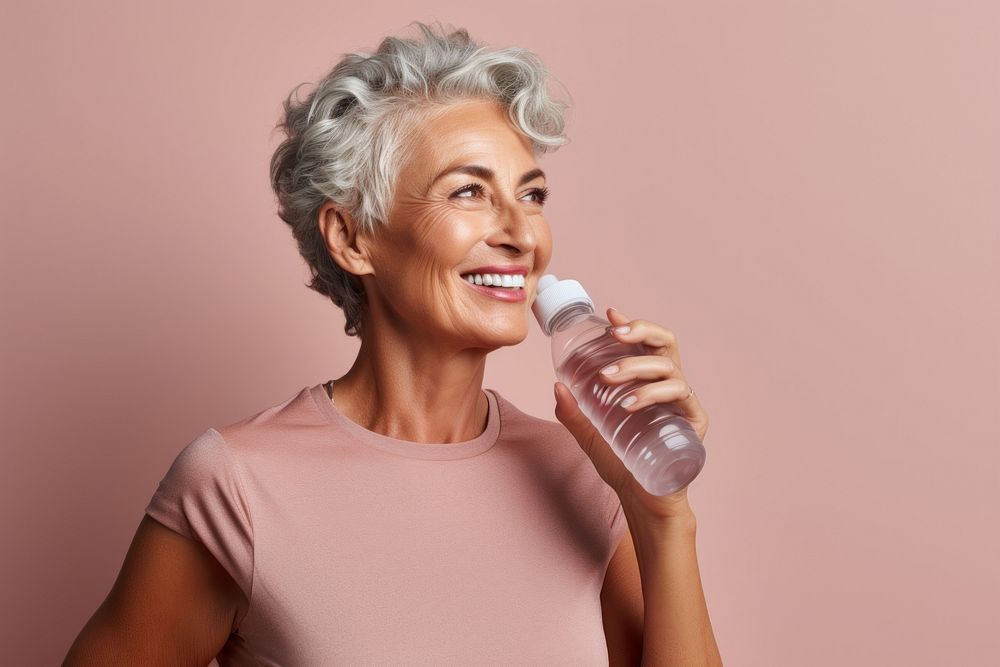 Senior woman in an active sportswear drinking thirsty adult.