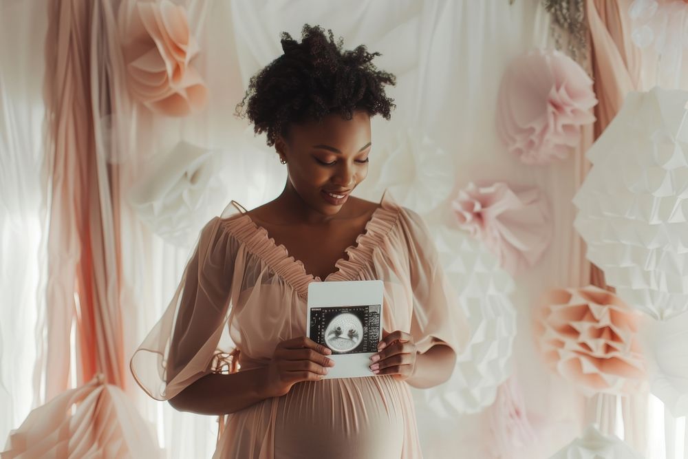 Black pregnant holding photo of pregnancy ultrasound portrait adult bride.