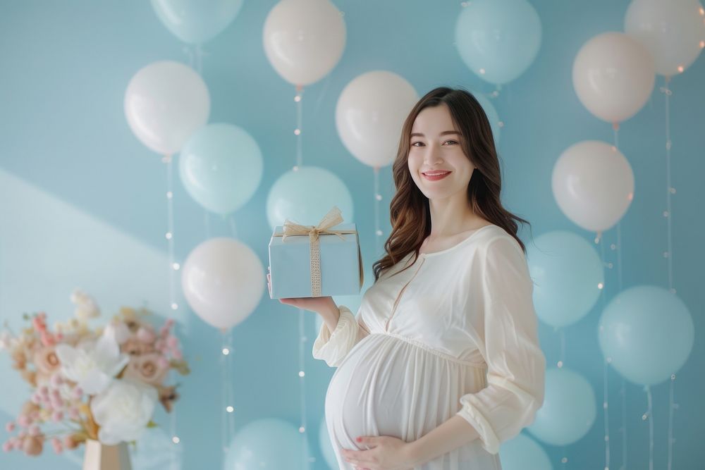 Woman holding present to give pregnant woman balloon party adult.