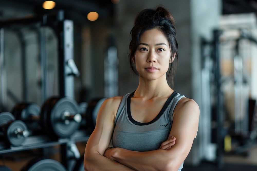 Asian multi ethnic personal trainer at gym adult weightlifting determination.