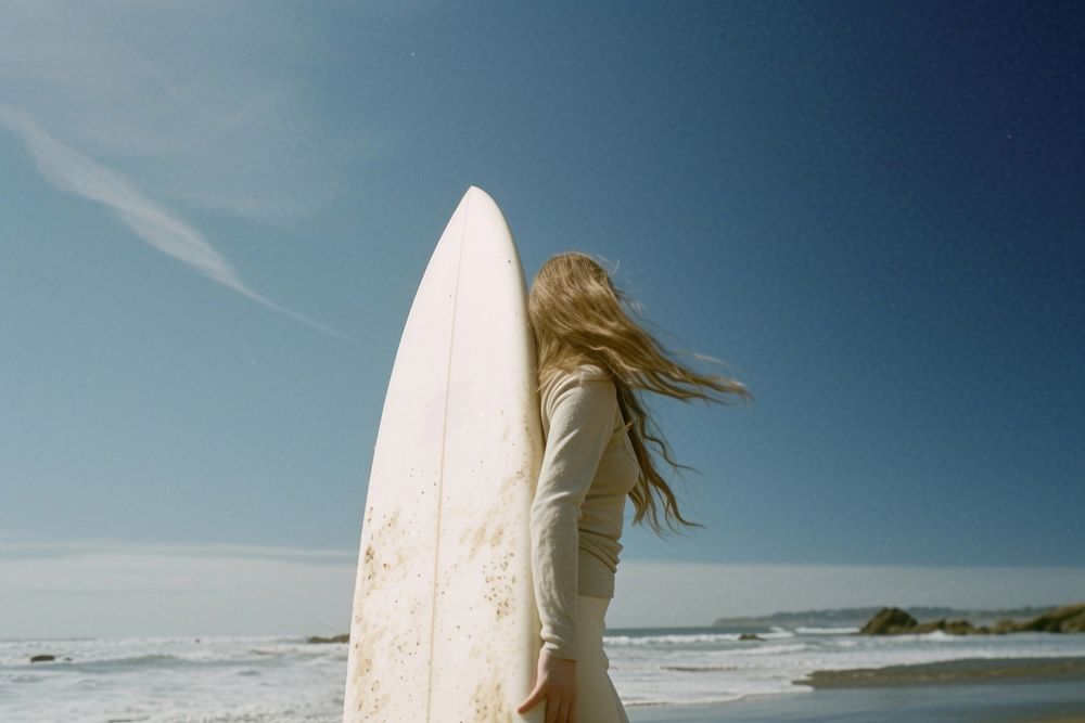 Woman carrying a white surfboard beach outdoors surfing.