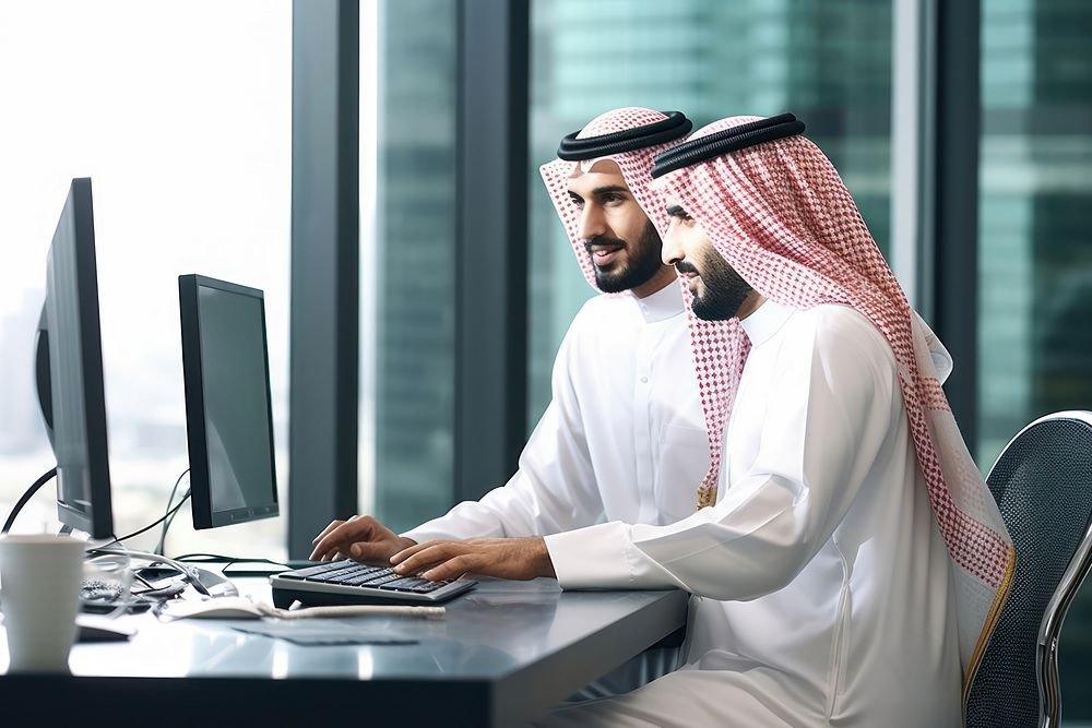 Saudi software engineers computer laptop office.