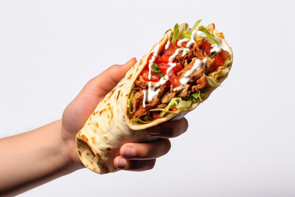 Female hand holds shawarma with red sauce bread food white background.
