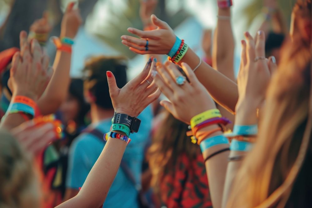A group of friends wearing Solza silicone wristbands at a music festival celebration atmosphere bracelet.