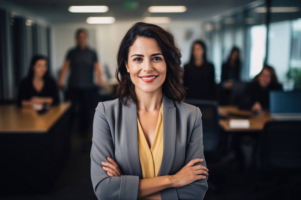 A business woman standing next to a screen in a meeting at the office smiling adult smile.