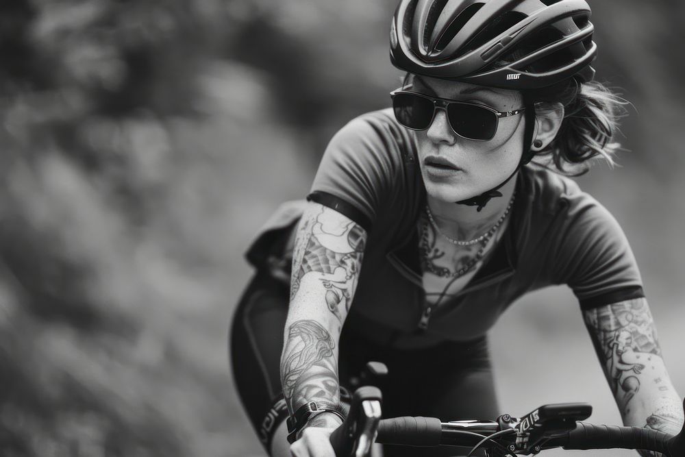 Female cyclist riding a bike with tattoos bicycle vehicle glasses.