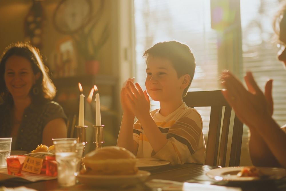 Cheerful family applauding for birthday boy table cheerful sitting.