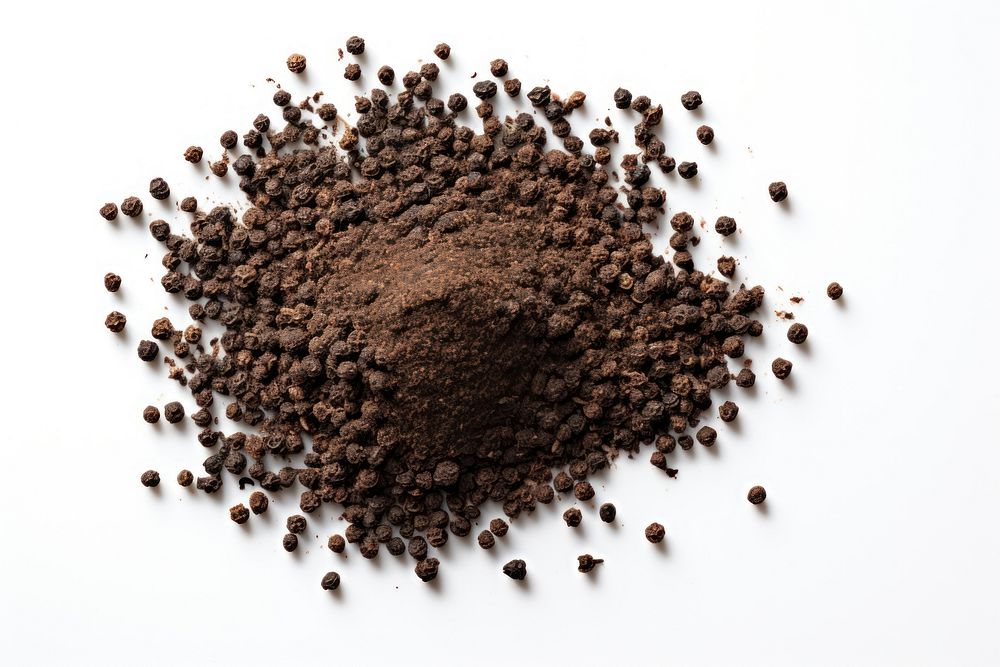 Ground black pepper flakes coffee soil white background.