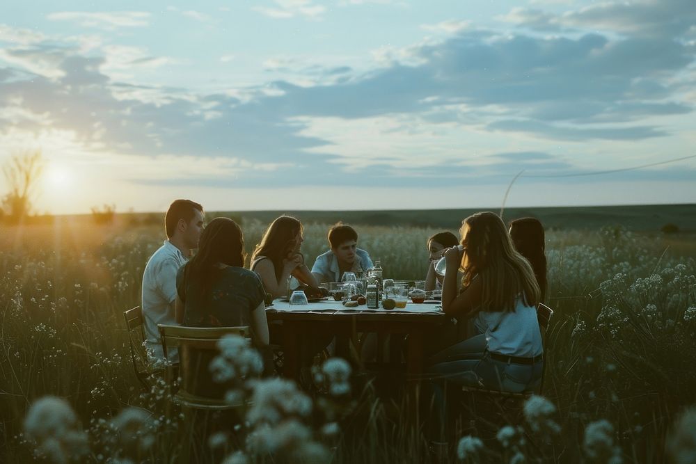 Group of friends enjoying dinner outdoors sitting nature.