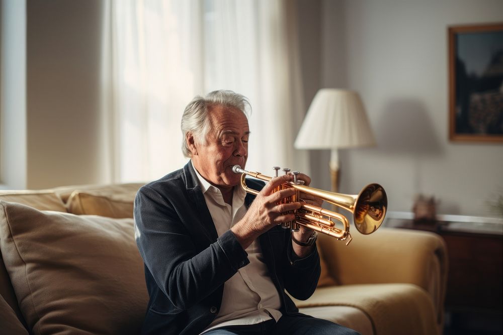 Senior man polishing trumpet at home adult concentration performance.
