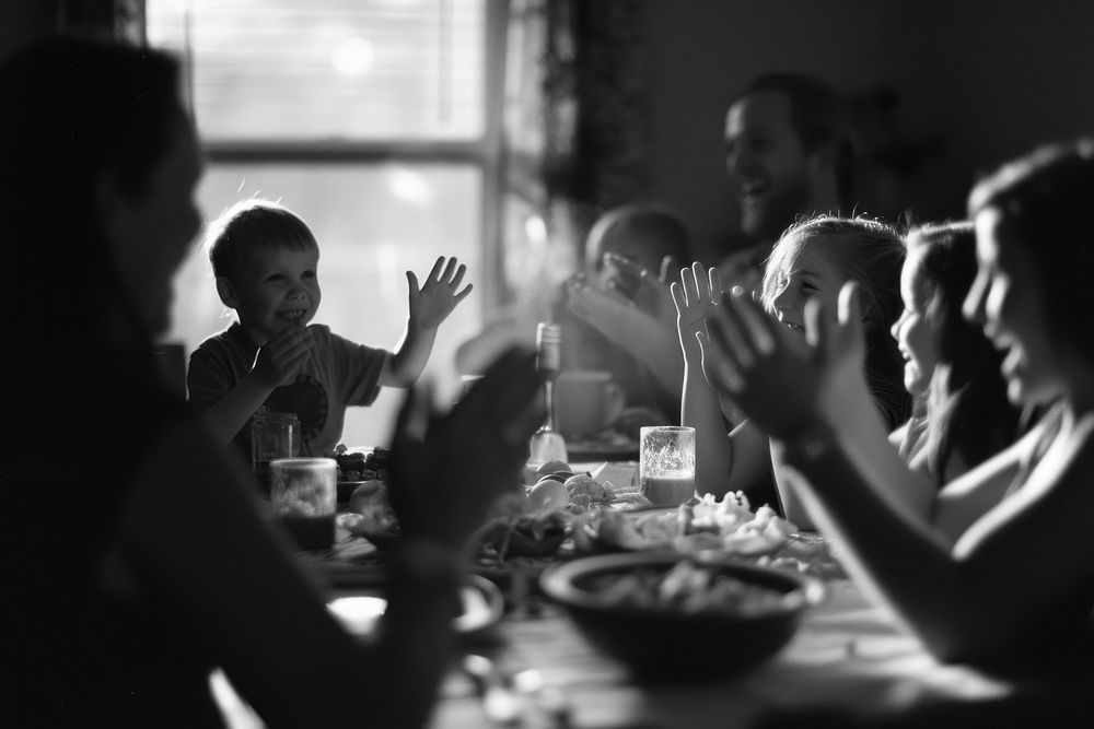 Cheerful family applauding for birthday boy sitting table adult.