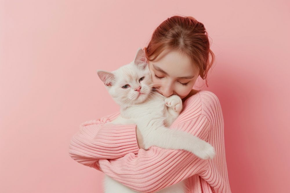 Person hugging a pet animal mammal kitten.