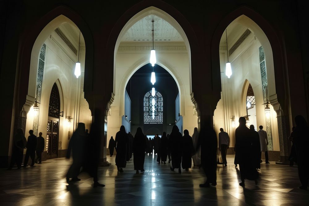 A mosque with silhouettes of people entering architecture building worship.