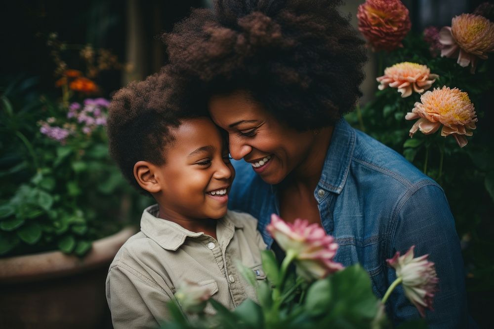 Son giving flower to mother laughing portrait child.