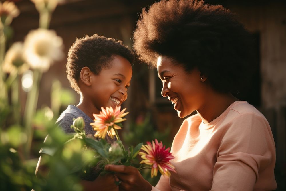 Son giving flower to mother laughing adult child.