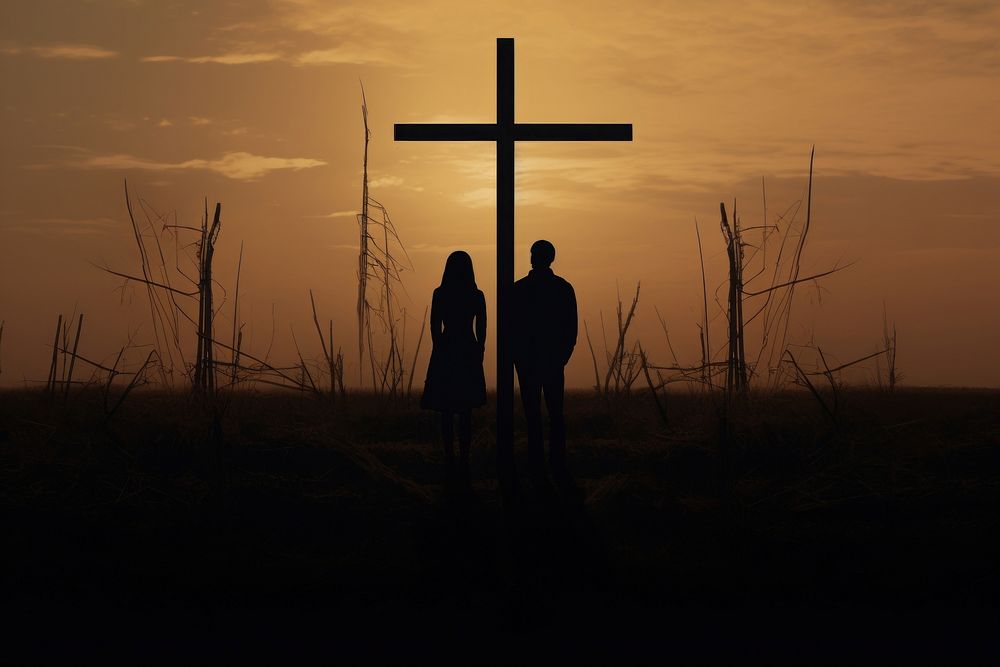 Couple silhouette at surreal wood cross backlighting outdoors.