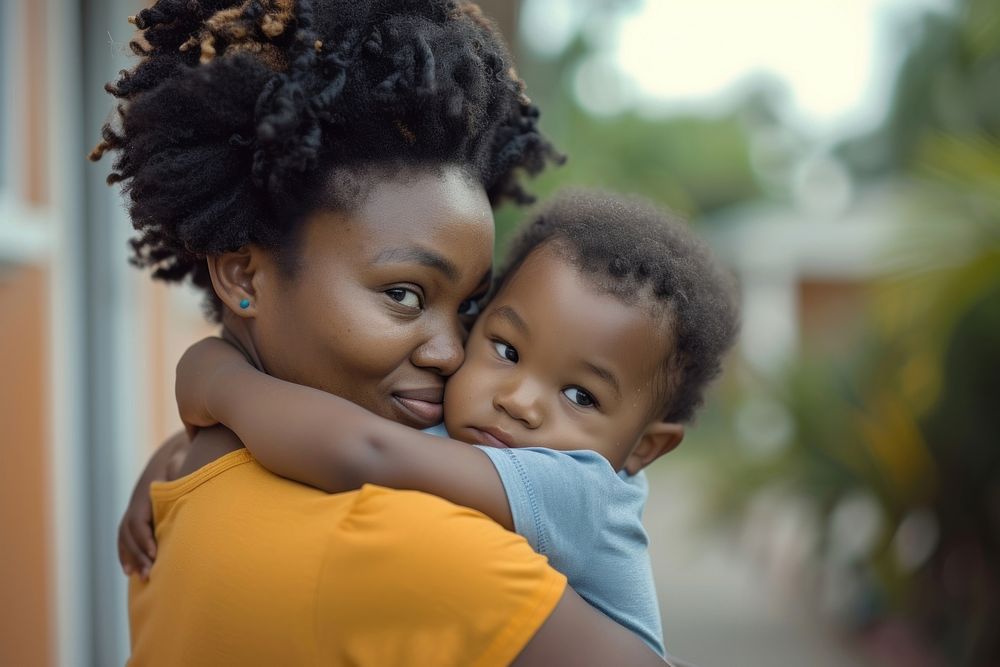 Black mother holding a toddler photography portrait hugging.