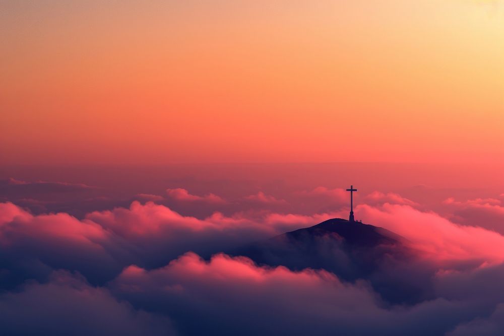 Silhouette of a cross on top of a hill cloud silhouette outdoors.