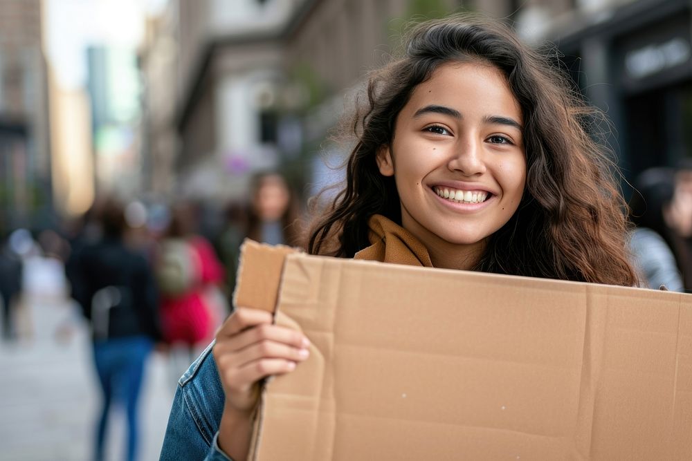 Young mixed race woman cardboard holding smile.
