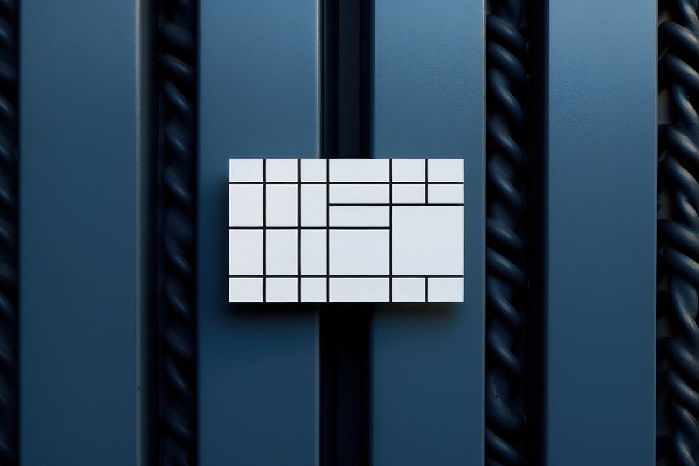 A business card is hanging on a black grid fence white blue wall.