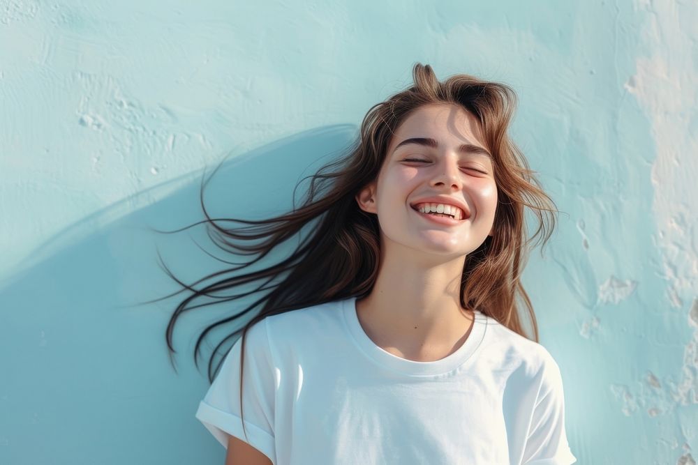 A happy woman wearing white t shirt laughing smile blue.