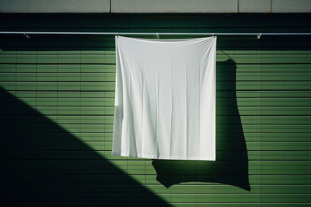 A paper is hanging on a black grid fence white green wall.