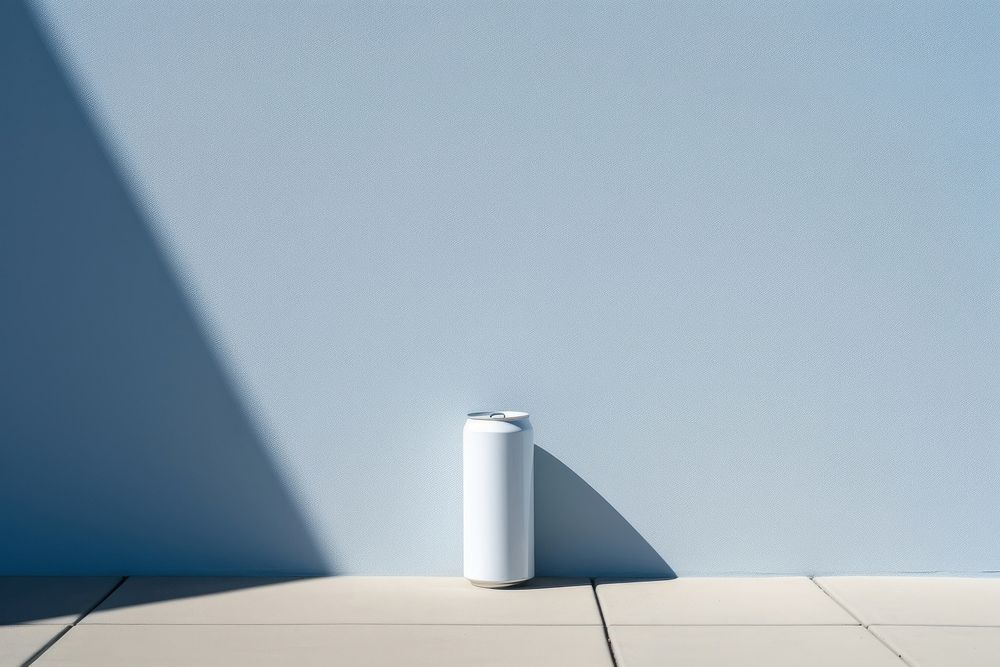 A white can is on a black grid fence wall architecture cylinder.