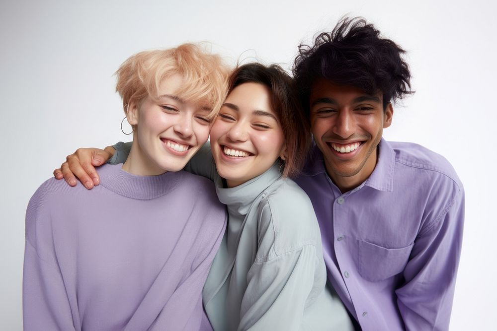 Three diverse young people laughing portrait hugging.