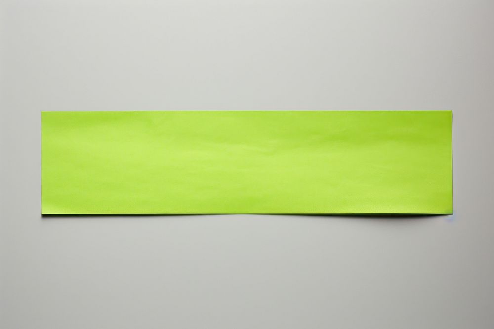 Piece of neon-green paper adhesive strip text white background rectangle.