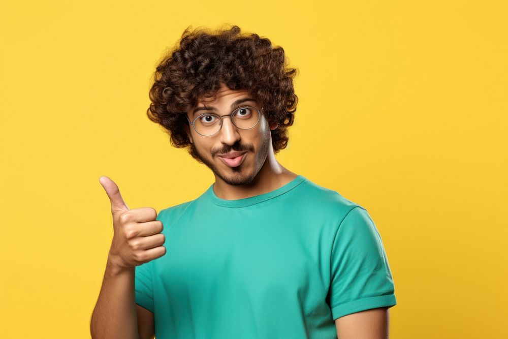 Indian man with curly hair glasses hand pointing.