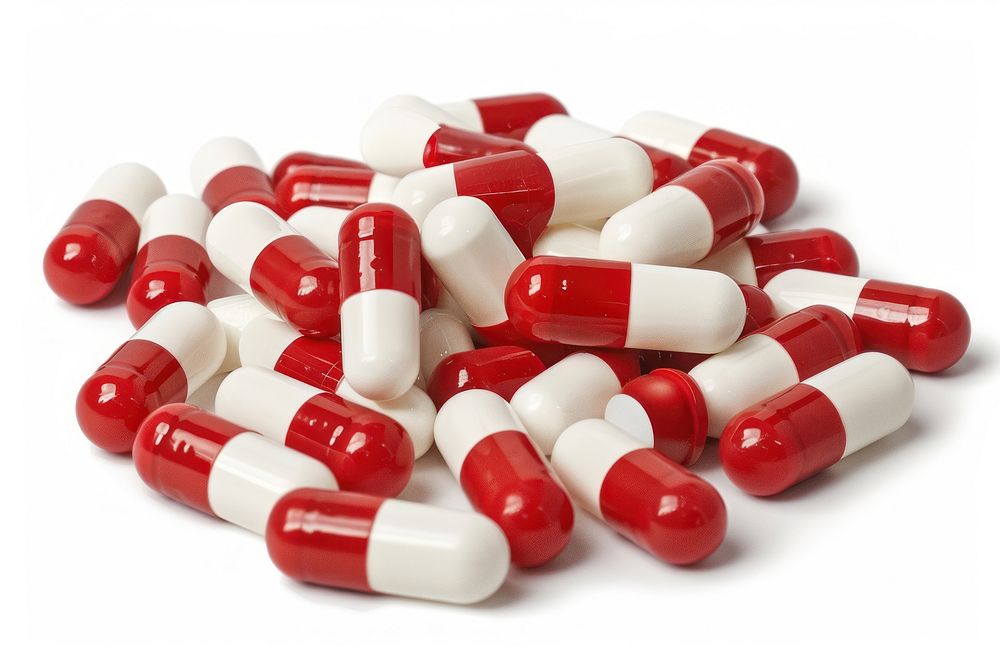 Pile of pill capsules red white background antioxidant.
