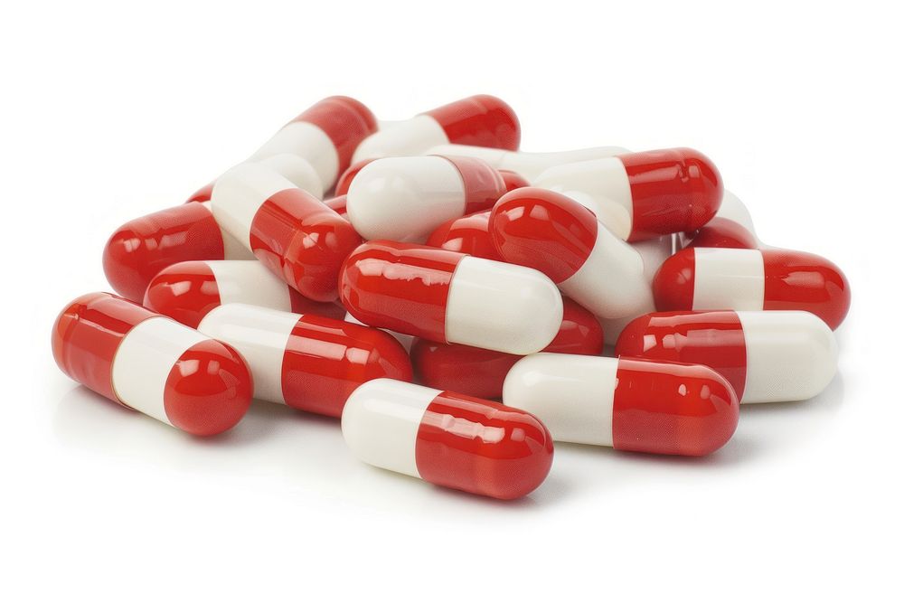 Pile of pill capsules red white background antioxidant.